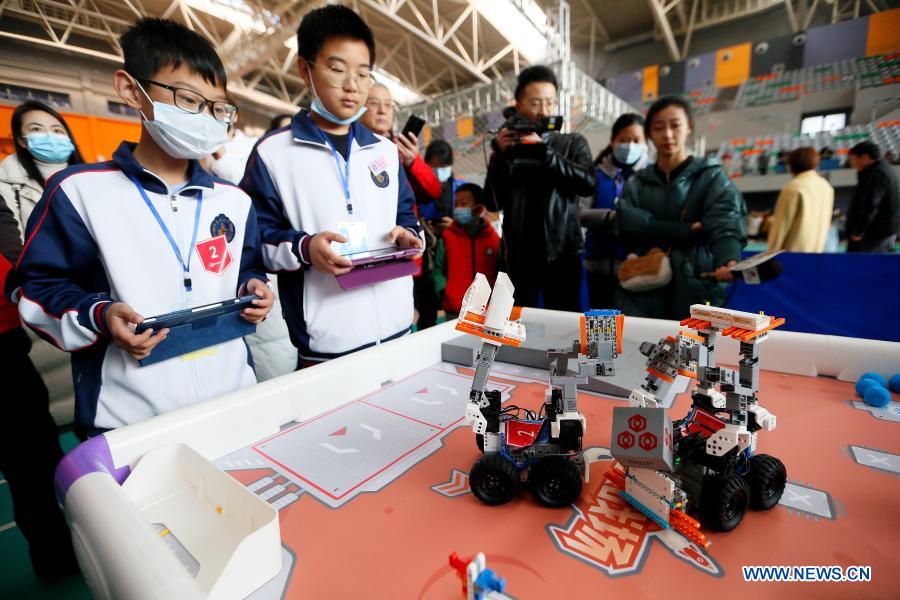 Contestants participate in a robot rescue match during a robotics competition for middle and primary school students in Jimo District of Qingdao, east China