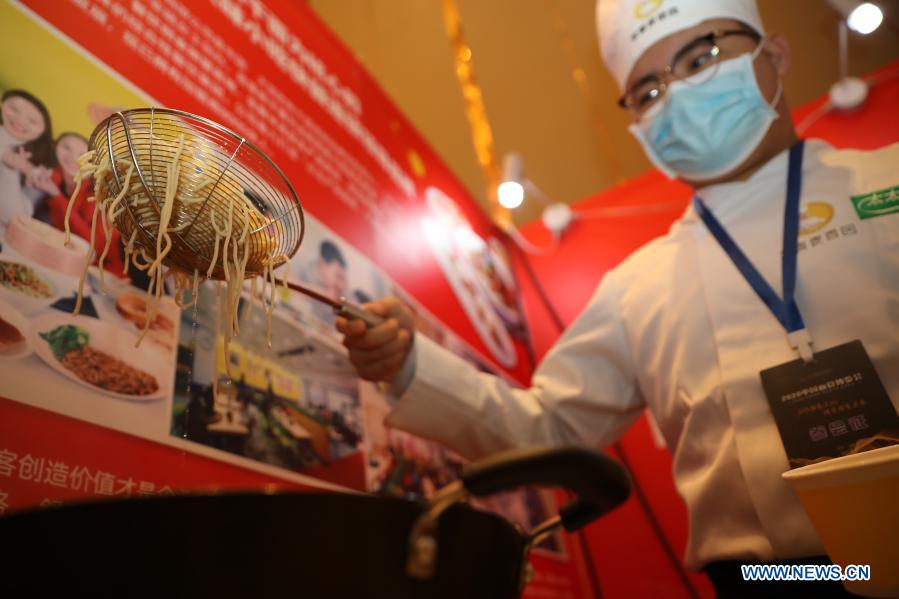 A chef makes hot dry noodles during the 2020 China Pasta Expo held in Lanzhou, northwest China