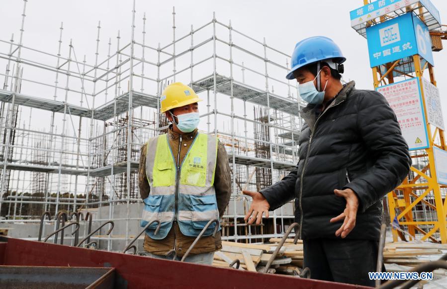 Zhang Xingfa (L) discusses welding solutions with a technician at a construction site in east China