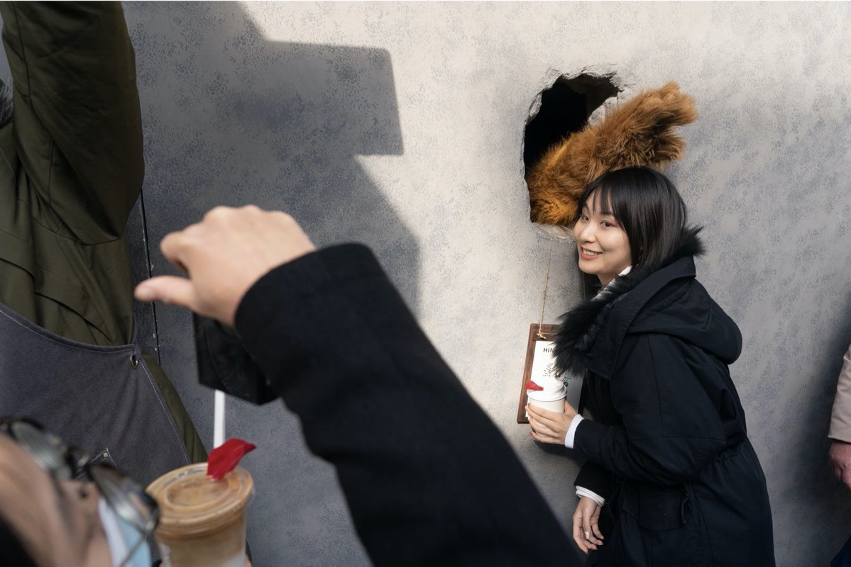 A woman poses for a photo at Hinichijou coffee shop in Shanghai. [Photo by Gao Erqiang/chinadaily.com.cn]