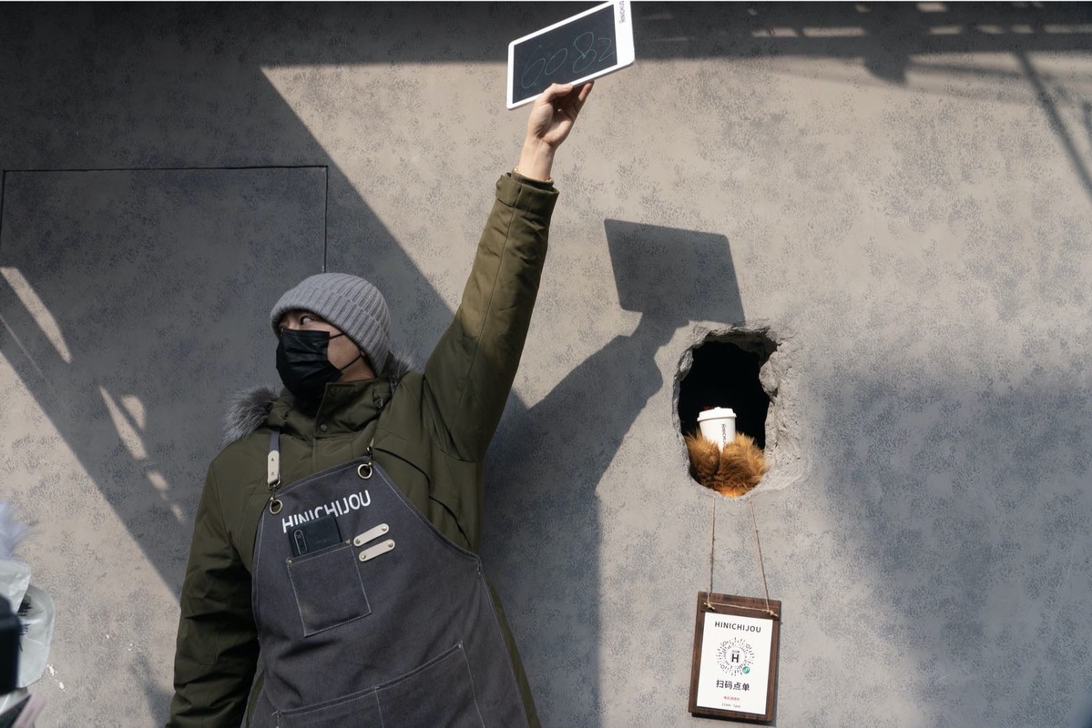 A staff member poses for a photo at Hinichijou coffee shop in Shanghai. [Photo by Gao Erqiang/chinadaily.com.cn]