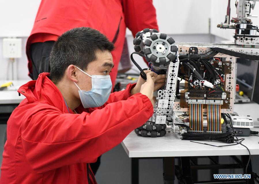 A contestant debugs a robot during the first vocational skills competition in Guangzhou, south China