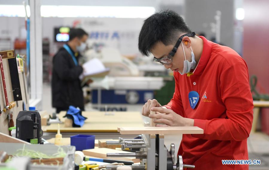 A contestant takes part in a woodworking contest during the first vocational skills competition in Guangzhou, south China