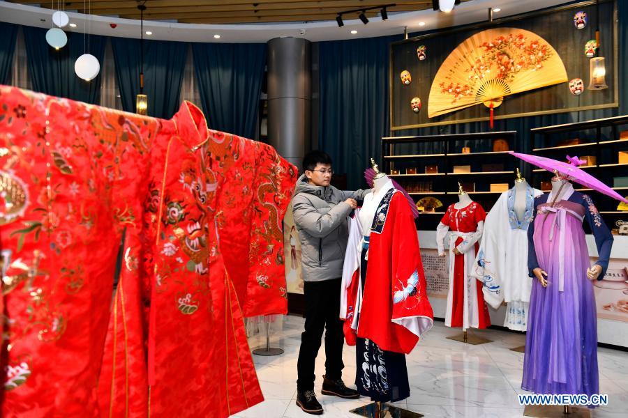 Hu Chunqing arranges the costumes for display at his studio in Caoxian County, east China