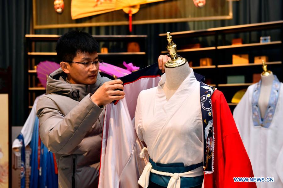 Hu Chunqing arranges the costumes for display at his studio in Caoxian County, east China