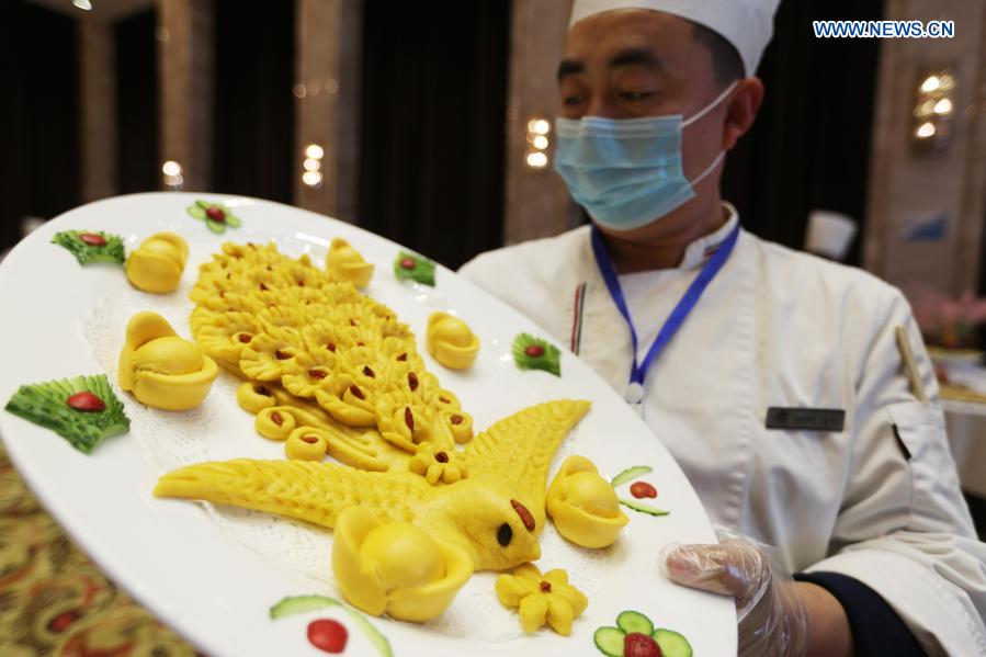 A chef presents his work during a cooking competition in Yinan county of Linyi City, east China