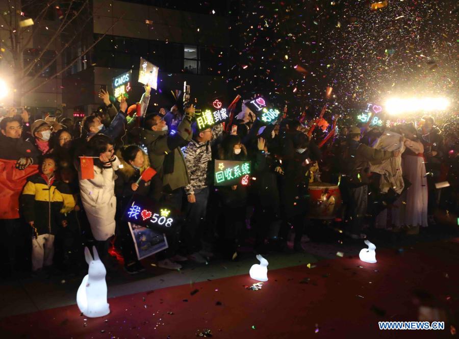 People celebrate the arrival of the return capsule of China