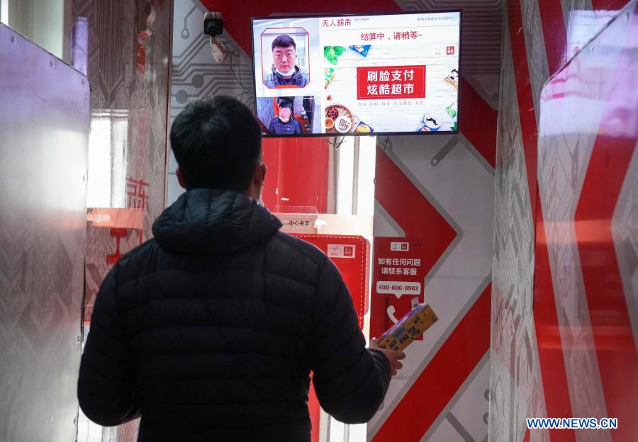 A customer scans his face to pay at a self-service supermarket in Xiong