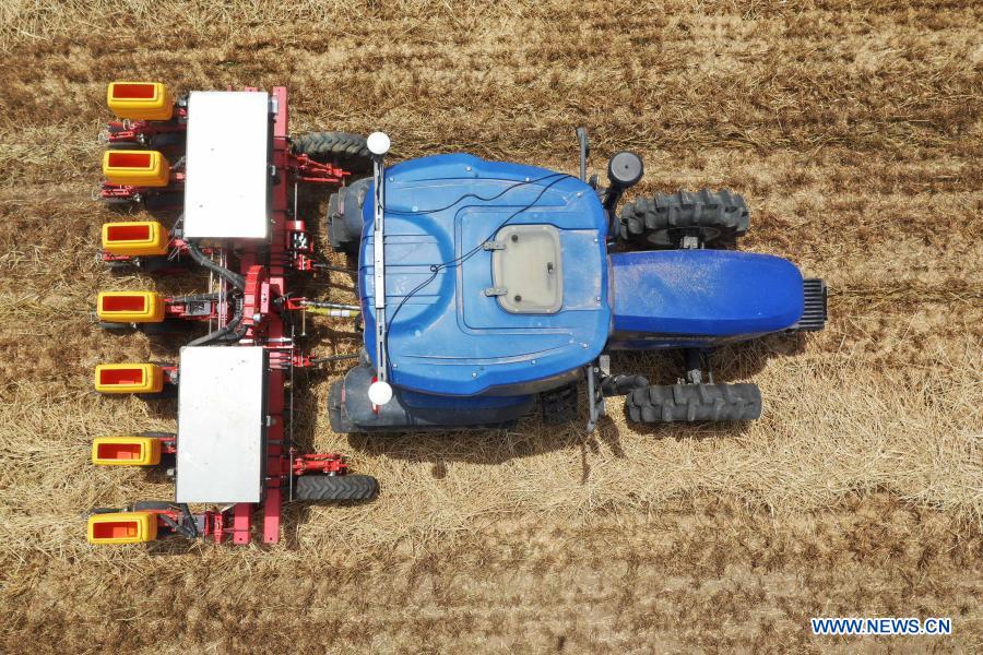 Photo taken on May 26, 2020 shows an unmanned tractor equipped with BeiDou Navigation Satellite System (BDS) sowing seeds in the field in Anzhong Village of Xiaoyangying Town in Dengzhou City, central China