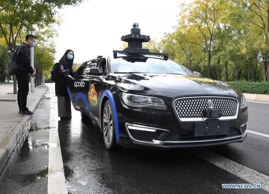 A woman takes a self-driving taxi at an appointed location on the Daoxianghu Road in Haidian District of Beijing, capital of China, Oct. 14, 2020. With the development of new technologies such as the 5G, artificial intelligence and BeiDou Navigation Satellite System (BDS), unmanned technology is injecting impetus into traditional industries as well as making people