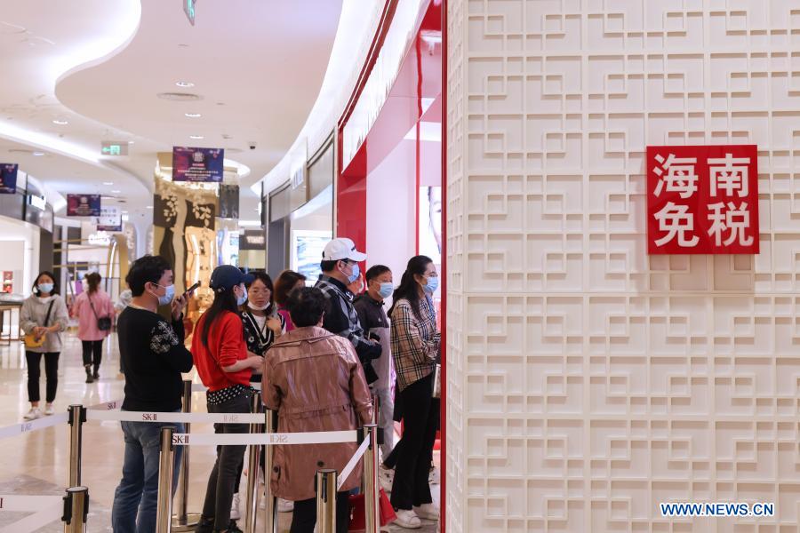 Consumers shop at a duty-free shop at Sun Moon Plaza in Haikou, capital of south China