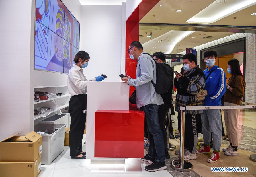 Consumers line up to check out at a duty-free shop at Sun Moon Plaza in Haikou, capital of south China