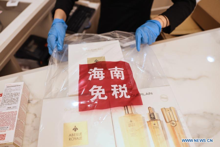 A staff member packages goods at a duty-free shop at Sun Moon Plaza in Haikou, capital of south China