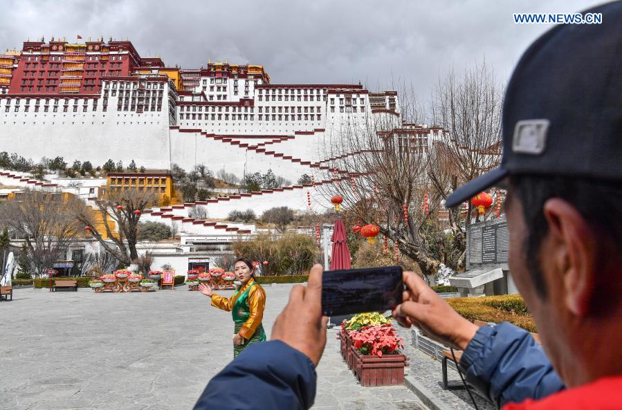 A tour guide (L) speaks during a livestreaming tour in the Potala Palace, a UNESCO world heritage site, in Lhasa, southwest China