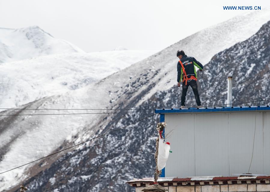 A worker installs broadband network in Bagar Village in Damxung County, southwest China