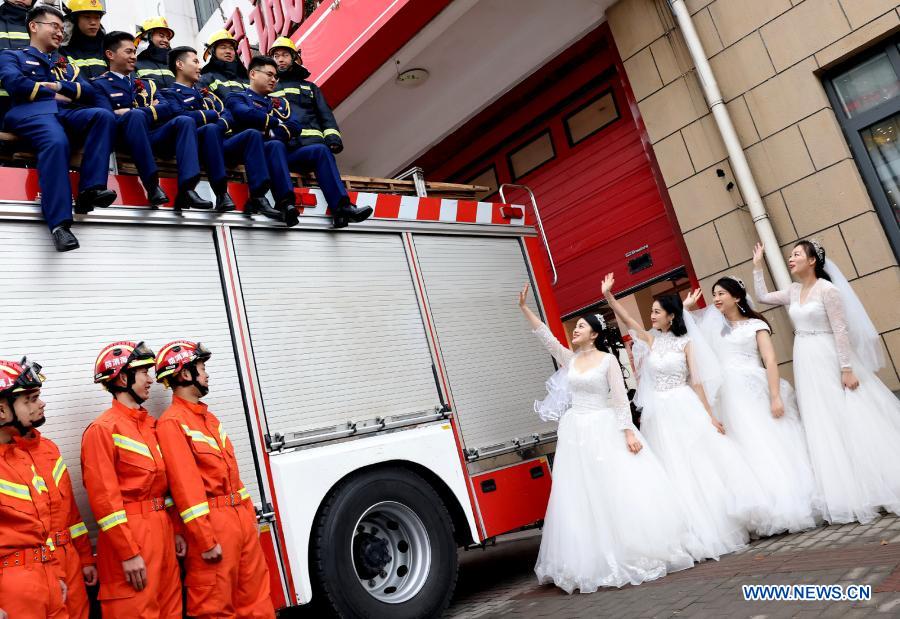 Firefighters and their wives pose for wedding photos during a group wedding ceremony in east China