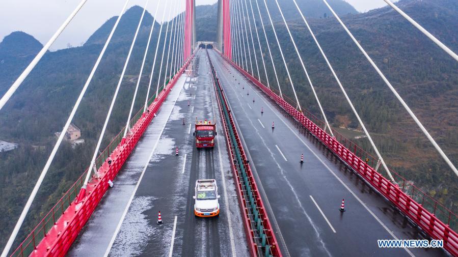 Aerial photo shows workers sprinkling salt to clear ice off the road on Yachi River Bridge in southwest China