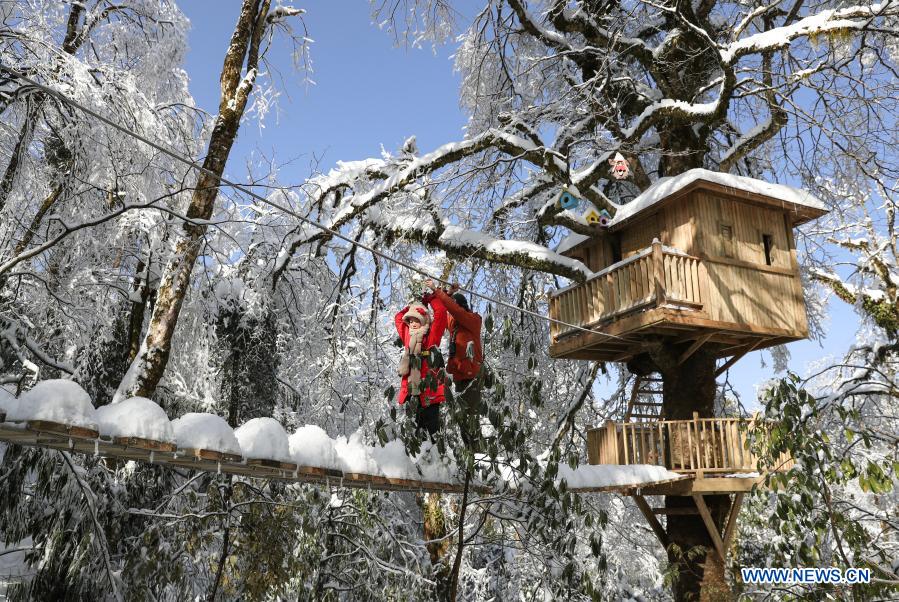 A student from Huchangbao Primary School heads to a tree house through a wire rope in Longcanggou National Forest Park in Yingjing County, southwest China