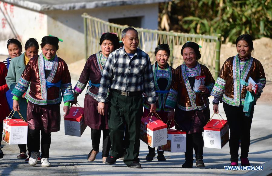 Lan Shengkui (4th R) carries noodles made with red sorghum flour at Wuying Village, which lies on the border between south China