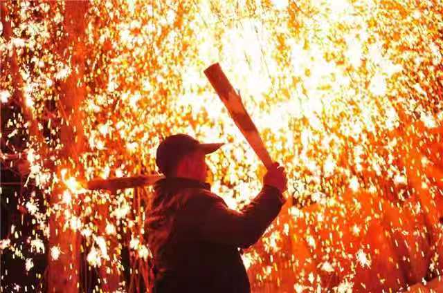 Performers throw hot molten iron against the tree branches, causing it to explode into a shower of sparks. [Photo provided to chinadaily.com.cn]Take a look at these sizzling photographs captured in the town of Dashu in Jining, East China