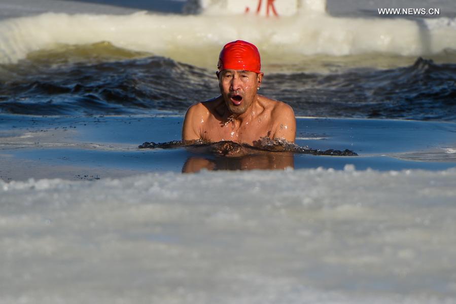 Yan Xiangbin swims in the icy water in Hulun Buir, north China