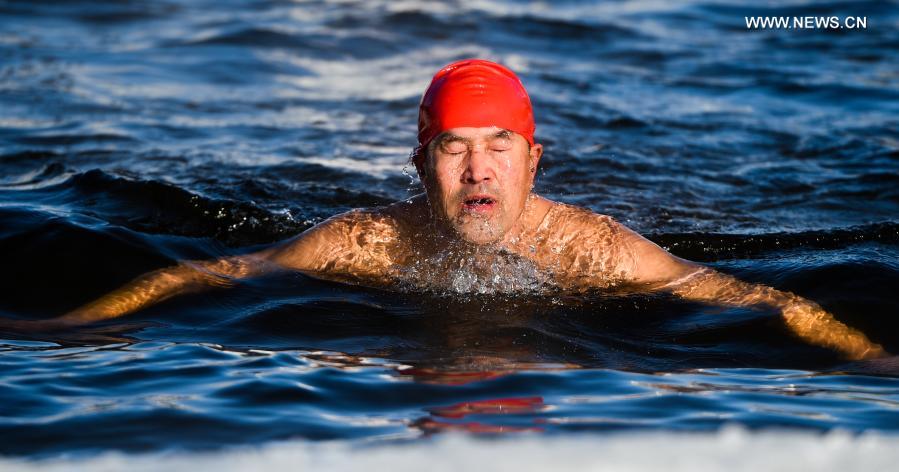 Yan Xiangbin swims in the icy water in Hulun Buir, north China