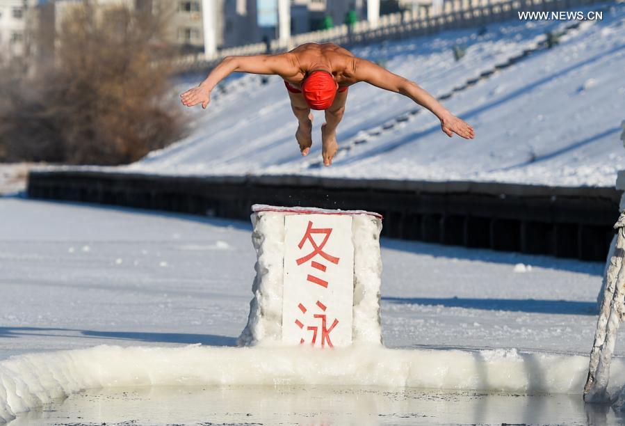 YYan Xiangbin jumps into the icy water in Hulun Buir, north China
