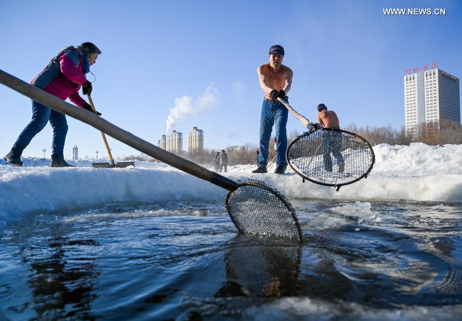 Yan Xiangbin (2nd R) clears floating ice in Hulun Buir, north China