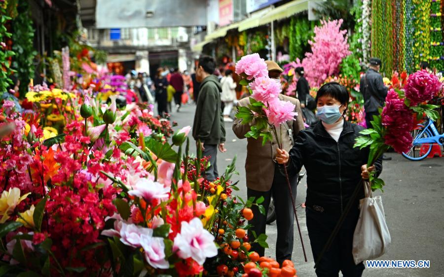 People select artificial flowers at a market in Haikou City, south China