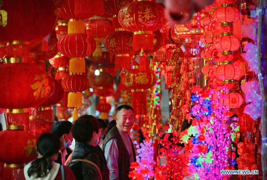 People select new year decorations at a market in Haikou City, south China