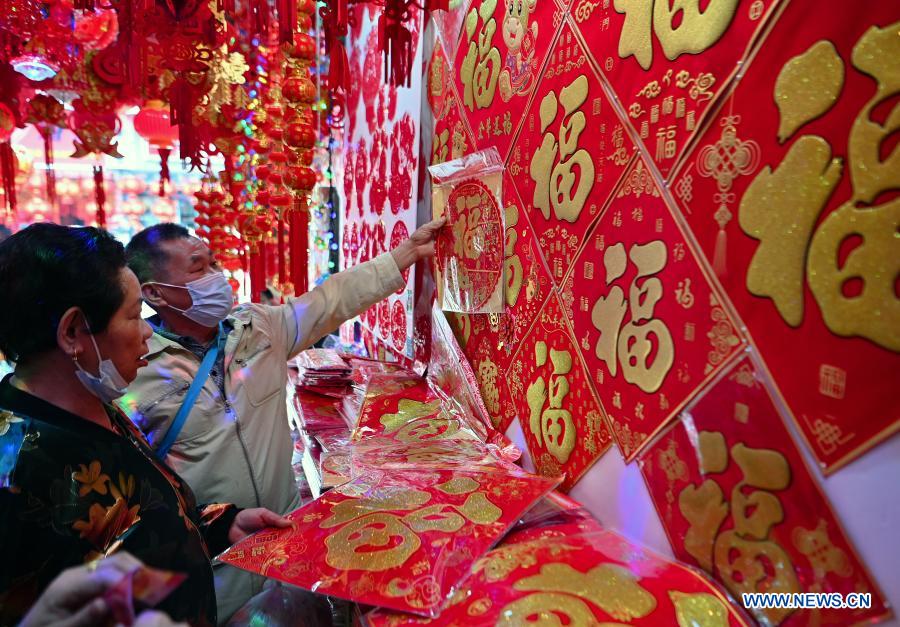 People select new year decorations at a market in Haikou City, south China