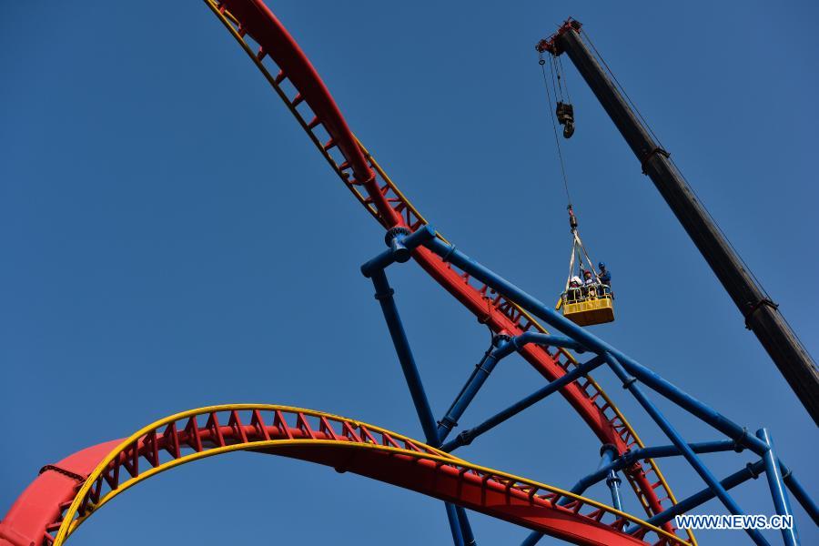 Maintenance workers carry out annual safety inspection on a roller coaster at Chimelong Tourist Resort in the run-up to the Lunar New Year holiday in Guangzhou, south China