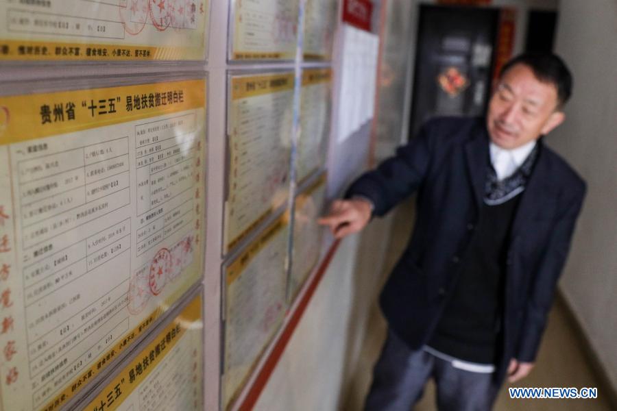 Yang Shaoshu presents the relocation information of his family at Jinxiu Huadu, a poverty-relief relocation site, in Qianxi County, Bijie, southwest China