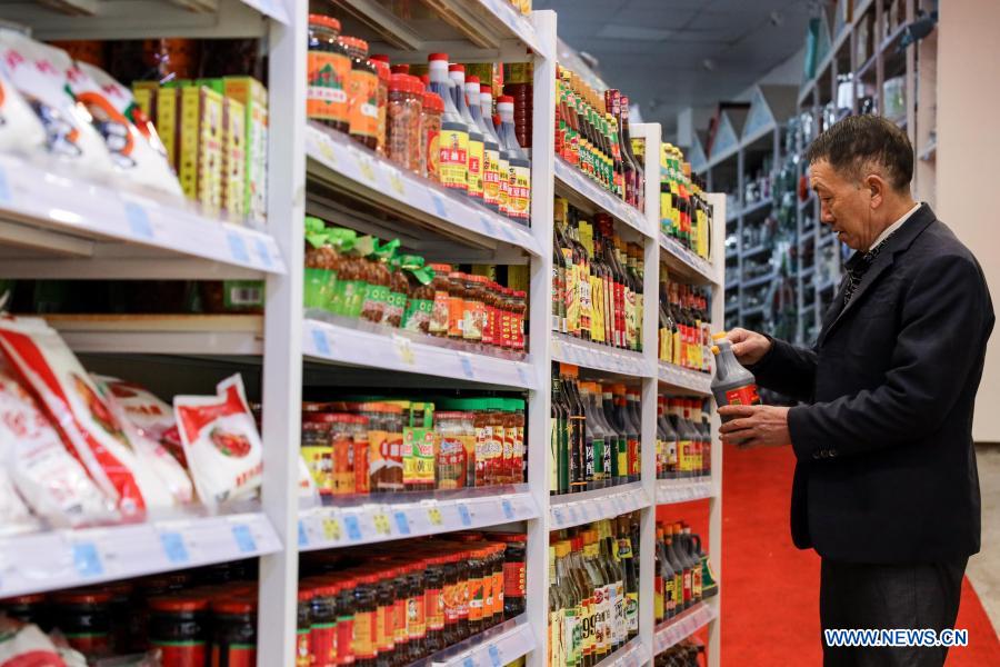 Yang Shaoshu shops at a supermarket in Jinxiu Huadu, a poverty-relief relocation site, in Qianxi County, Bijie, southwest China