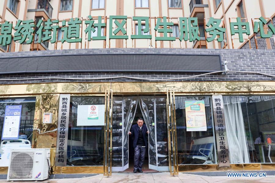 Yang Shaoshu walks out of the community health service center of Jinxiu Sub-district in Qianxi County, Bijie, southwest China