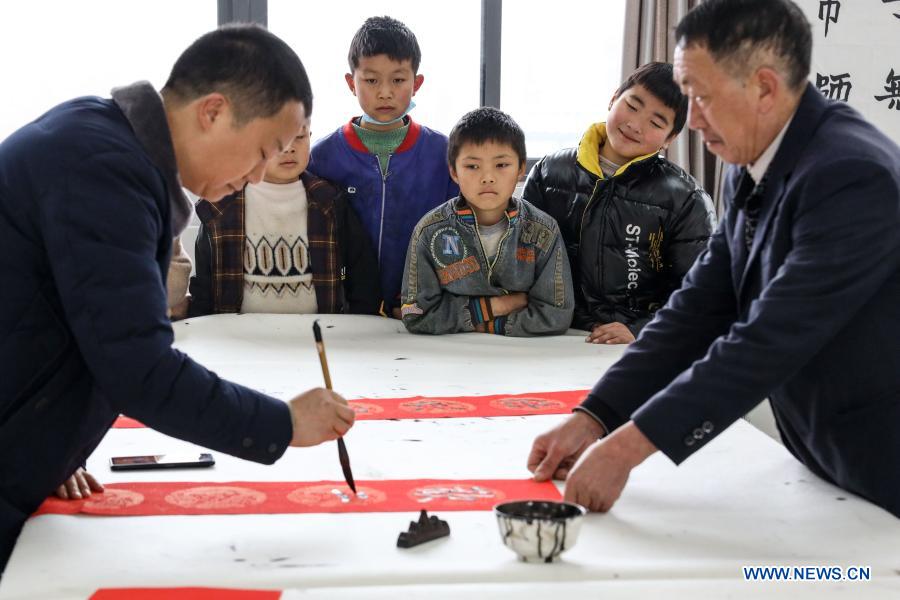 Students of Jinxiu Huadu, a poverty-relief relocation site, take part in a Spring Festival couplets writing activity at Jinxiu School in Qianxi County, Bijie, southwest China
