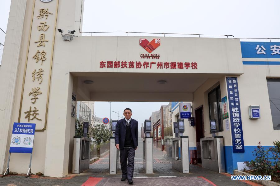 Yang Shaoshu walks out of Jinxiu School in Qianxi County, Bijie, southwest China