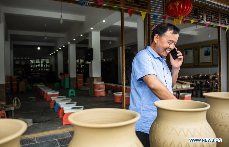 Mu Xiancai takes order via phone from one of his clients at Huamao Village, Bozhou District, Zunyi City of southwest China