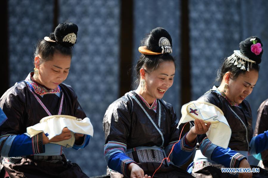 Women of the Dong ethnic group make embroideries at a farmers