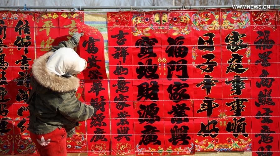 A vendor arranges couplets at a traditional Spring Festival fair held in Bayuquan District of Yingkou, northeast China