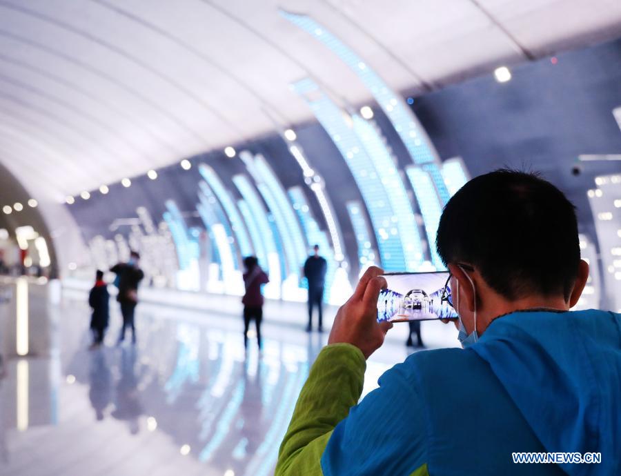 A passenger takes photos at Wuzhong Road Station of Shanghai Subway Line 15 in Shanghai, east China, Feb. 9, 2021. The Shanghai Subway Line 15 started trial operation on Jan. 23. (Xinhua/Fang Zhe)