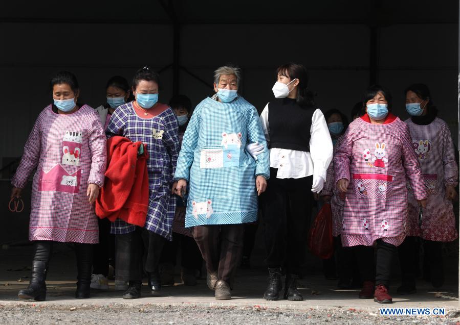 Yan Jiaxin (2nd R) and other female workers walk out of Yan