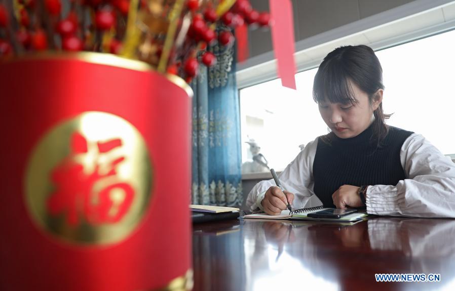 Yan Jiaxin calculates the materials needed to make handicraft goods in Qiaotuo Village of Tai