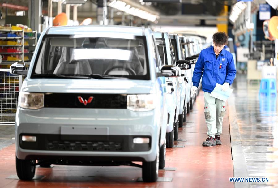 A worker checks new energy vehicles in Liuzhou, south China