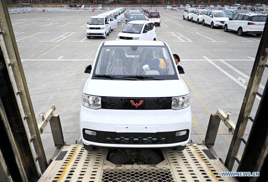 A worker drives a new energy vehicle into a transport vehicle at a logistics park in Liuzhou, south China