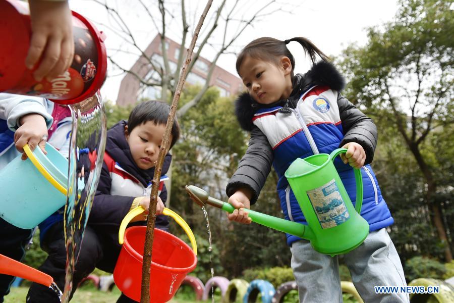 Children plant saplings at their kindergarten in Jianye District of Nanjing, east China