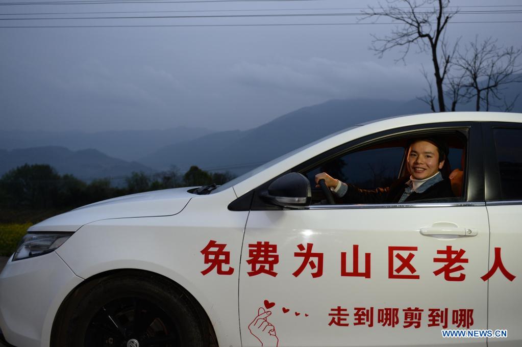 Zhuo Yihang is seen on a car posted with free haircut service information in Cili County, central China