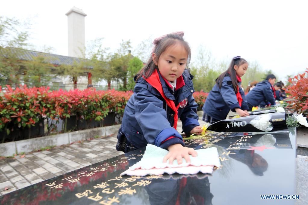 Students clean tombstone at a cemetery for martyrs in Huaibei, east China