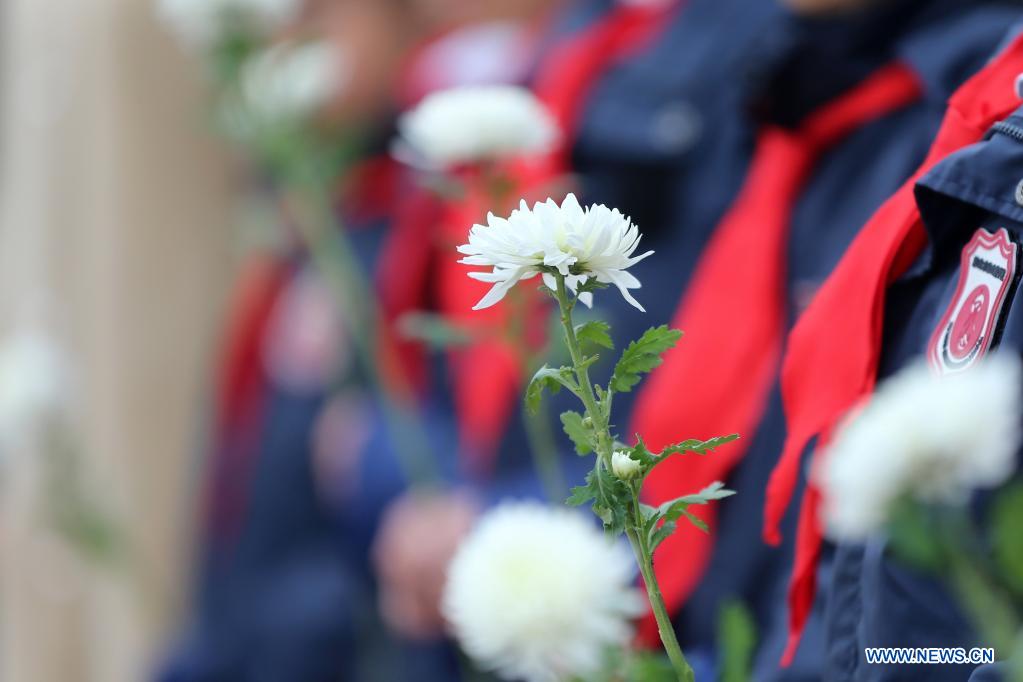 Students offer flowers at a cemetery for martyrs in Huaibei, east China