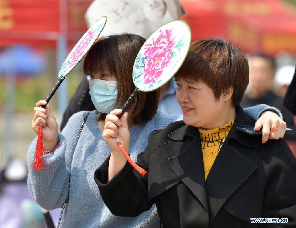 People holding peony fans visit a peony garden in Heze City, east China